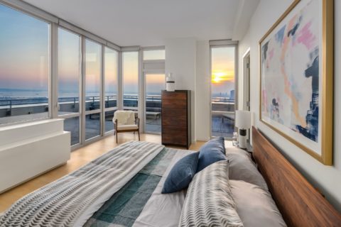 bedroom leading to terrace with expansive views at sunset