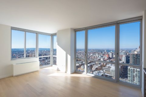 Photo of empty apartment with floor to ceiling windows and natural light